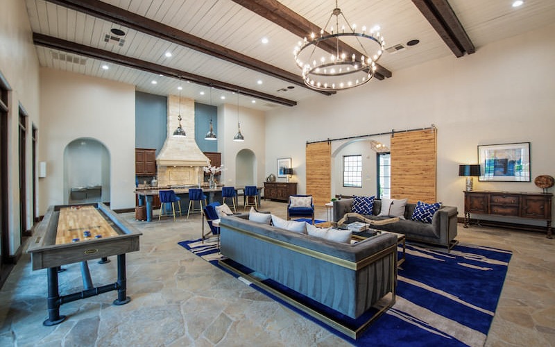 Lounge and entertainment room at our luxury apartments in Grapevine, TX, featuring shuffleboard and couches.